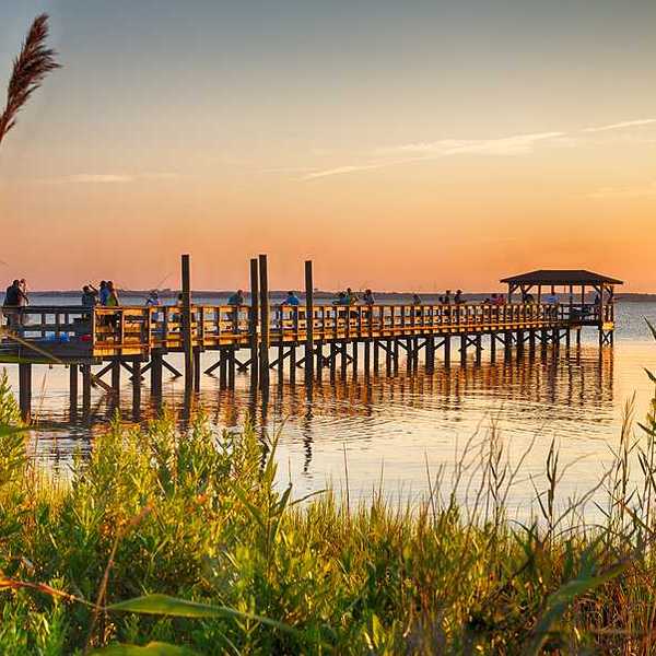 A view of the Cape Fear river with a wood dock stretching over the water