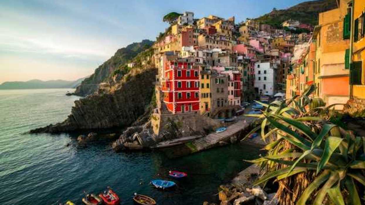 A view of the coastline of Cinque Terre with colorful buildings lining a hillside above the water
