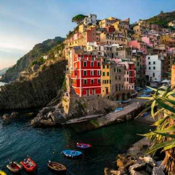 A view of the coastline of Cinque Terre with colorful buildings lining a hillside above the water