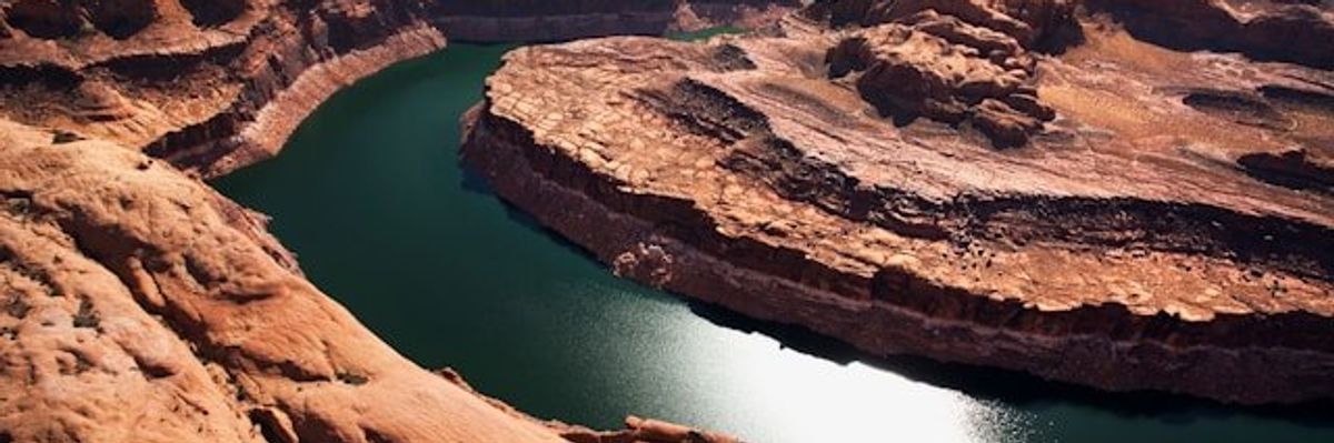 A view of the Colorado River winding through a dry rocky landscape.