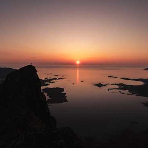 A view of the ocean with a sunset in the background