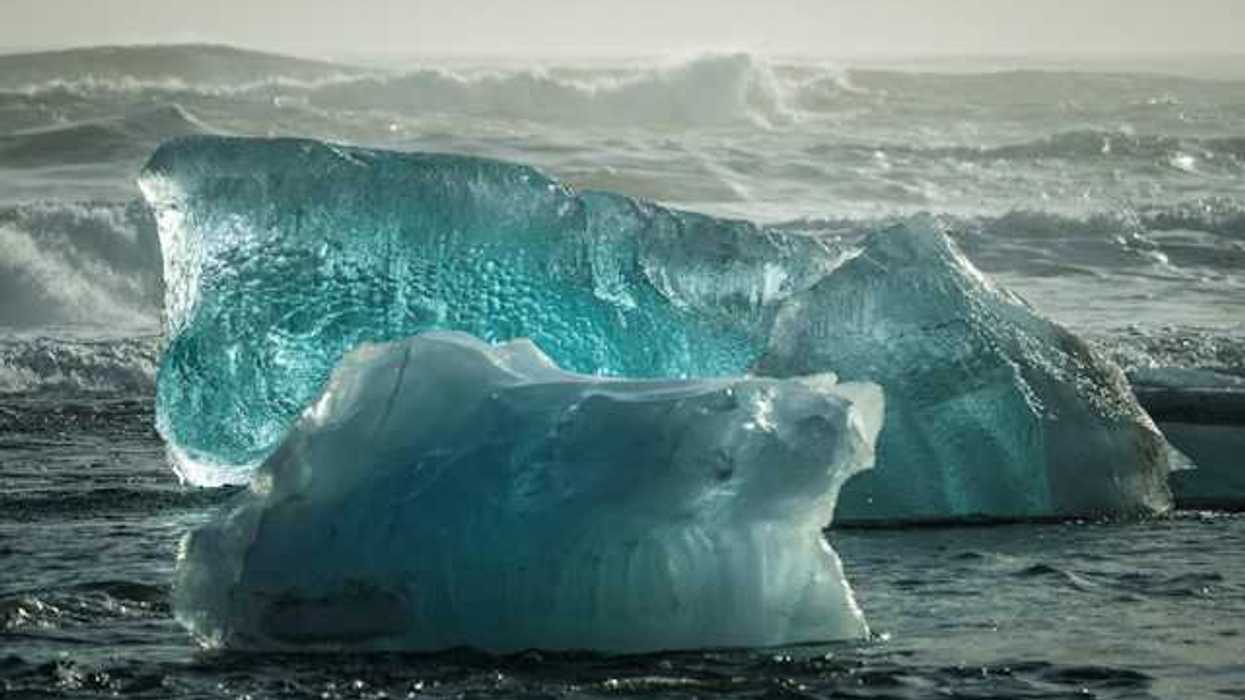 A view of the ocean with two big icebergs floating in it