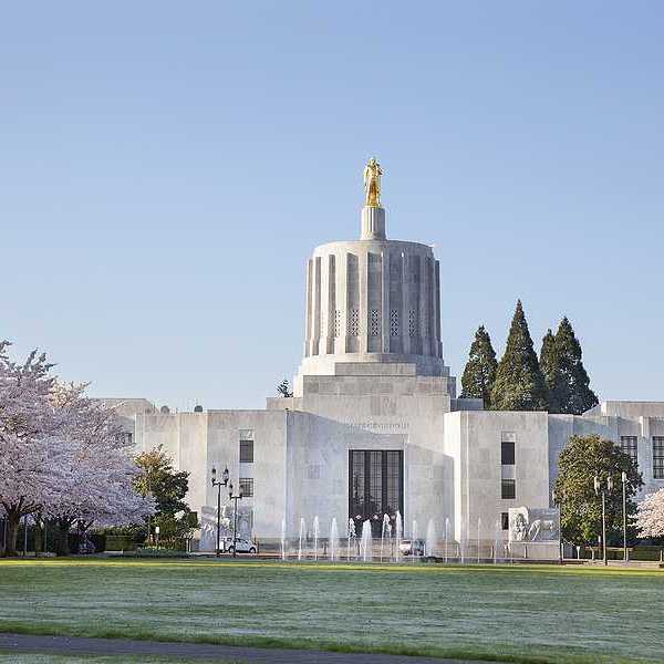 A view of the Salem, Oregon state house with green lawn in the foreground