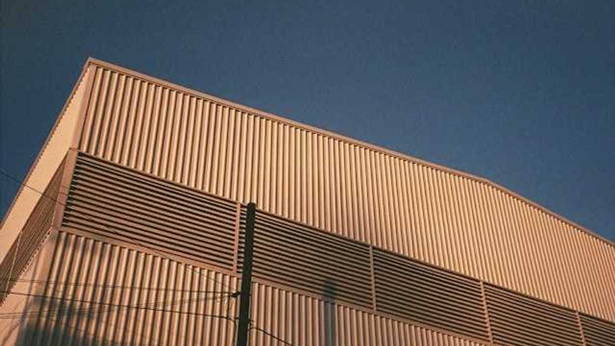 A view of the side of a warehouse building with the blue sky in the background