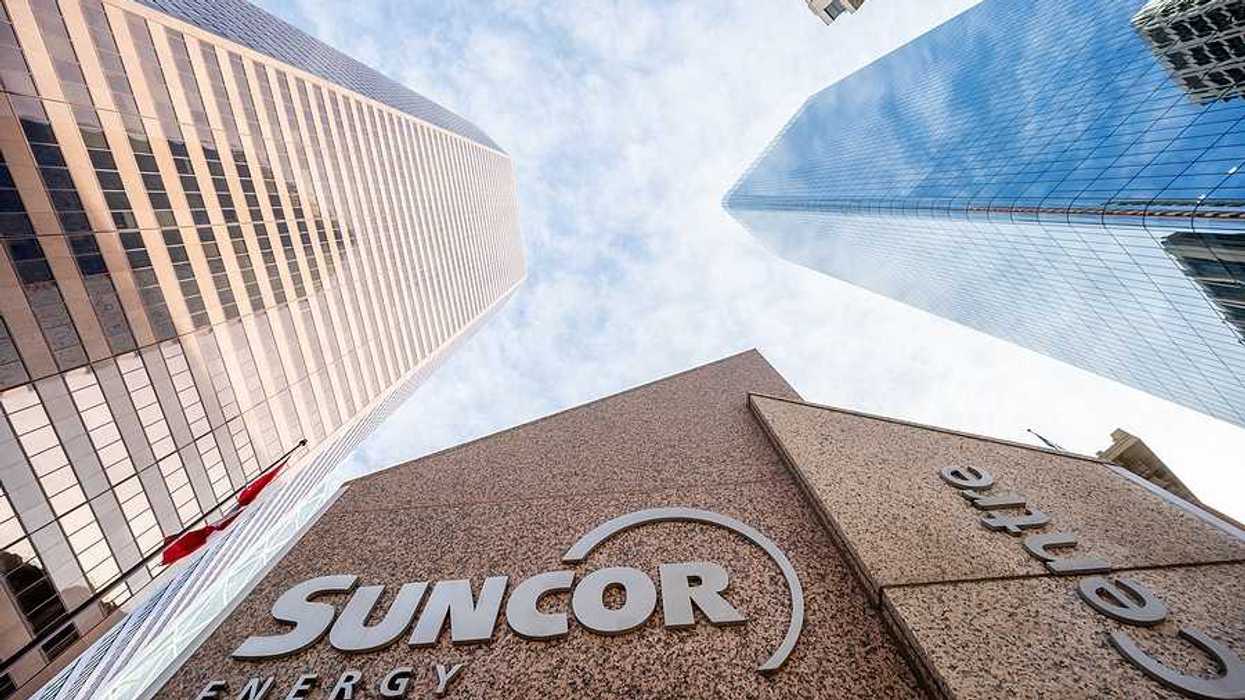 A view of the Suncor Energy building with skyscrapers and blue sky