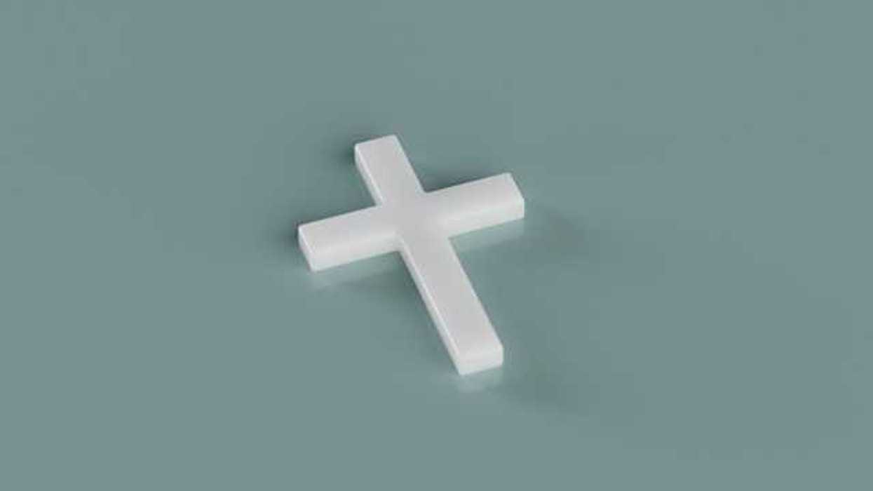 A white cross sitting on a green background