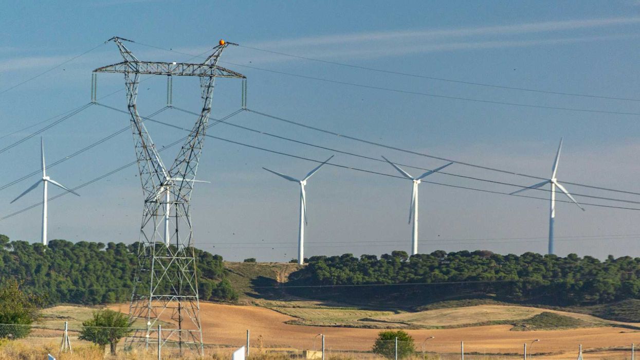 a wind farm with wind turbines in the background.