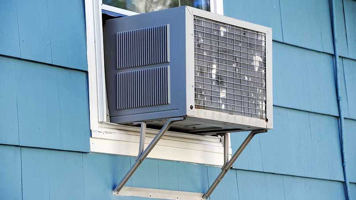 A window air conditioner viewed from the outside of a house