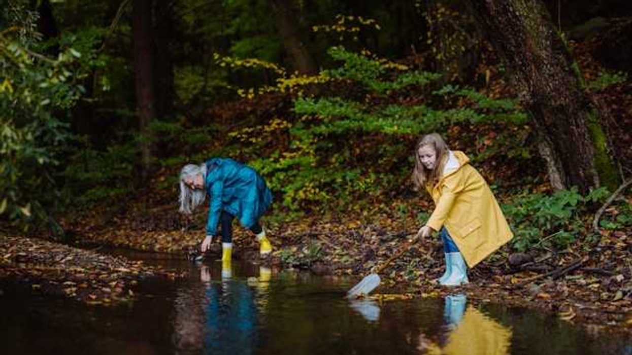 A woman and a child gathering plastic trash from a river