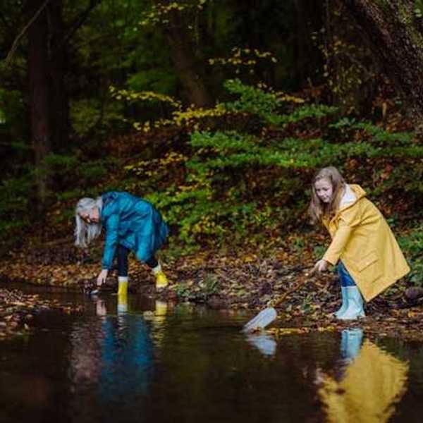 A woman and a child gathering plastic trash from a river