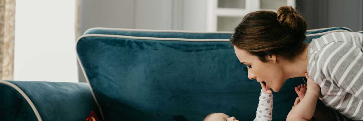 A woman and baby sit next to plastic toys