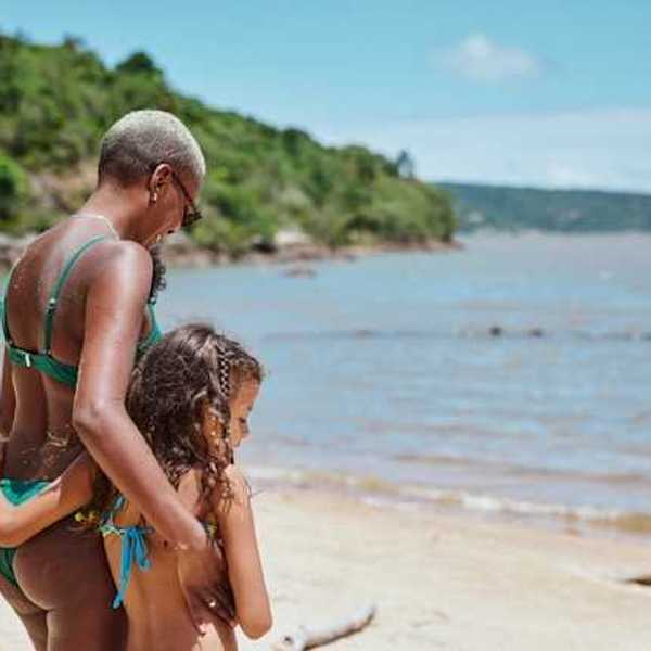 A woman and child standing on a Caribbean beach