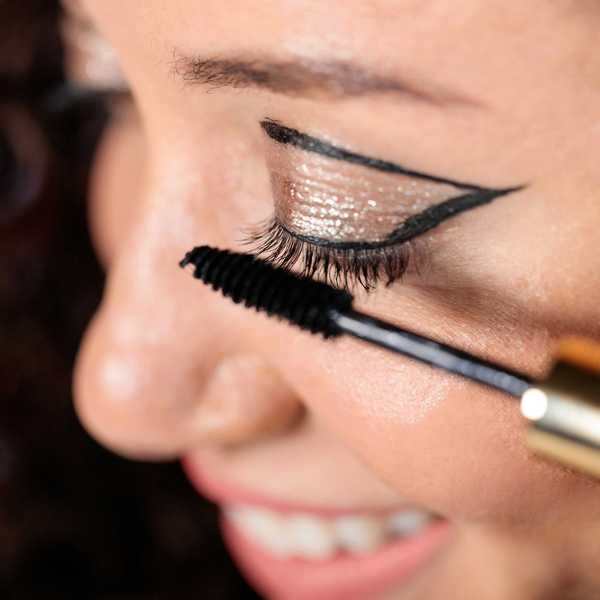 A woman applying mascara.