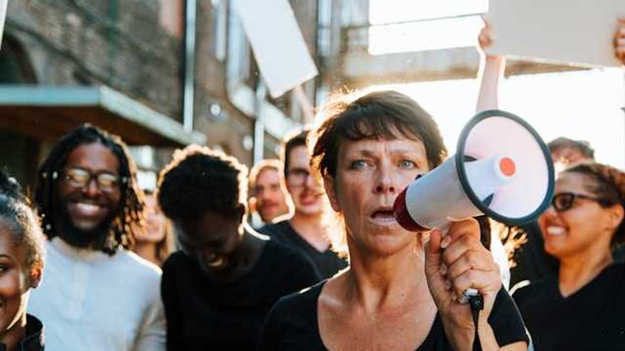 A woman at the front of a protest holding a microphone
