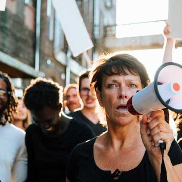 A woman at the front of a protest holding a microphone