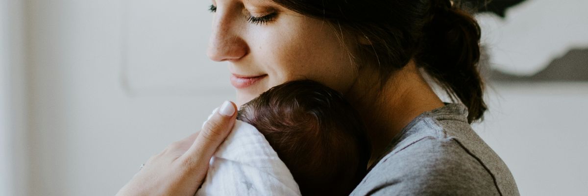 A woman carries a baby