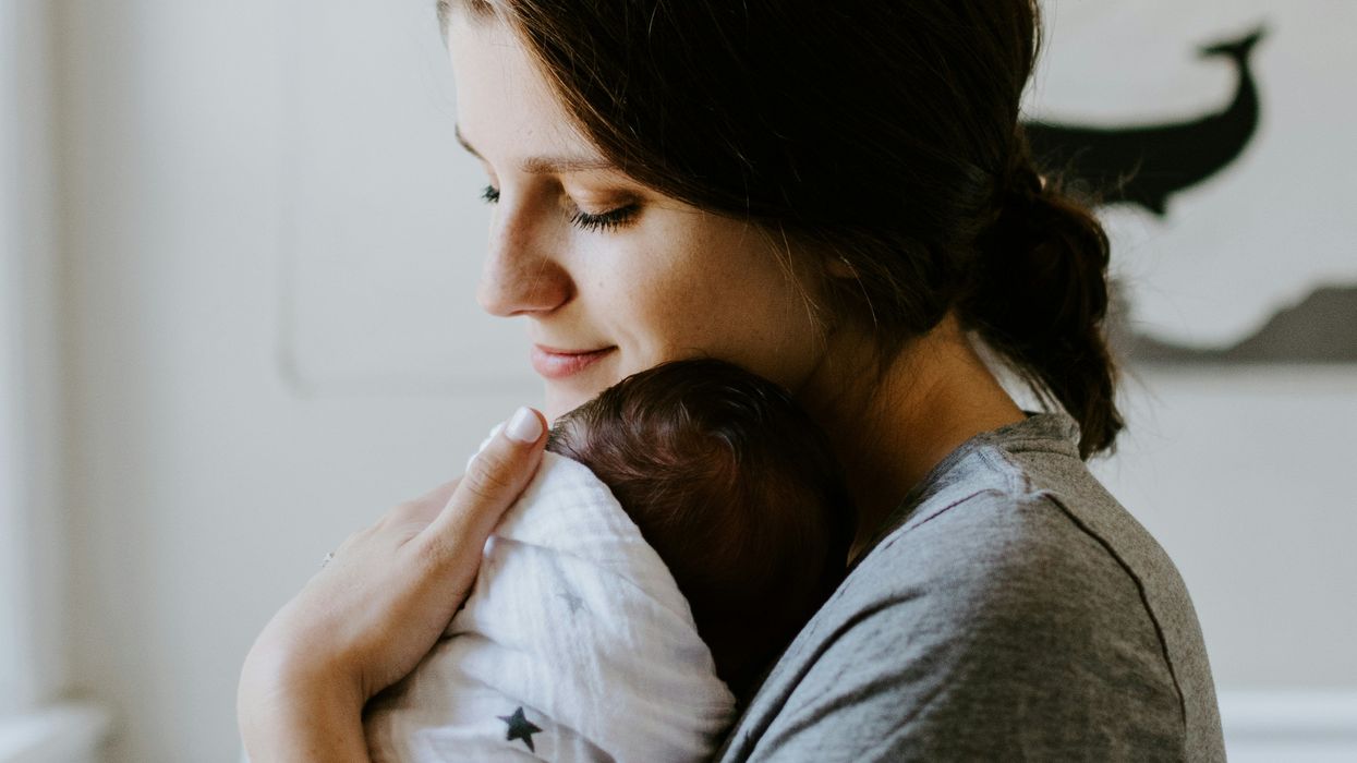 A woman carries a baby