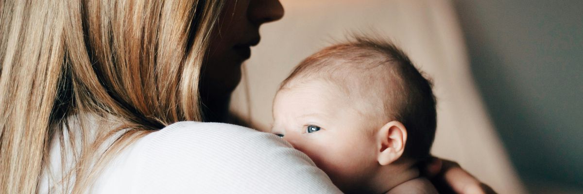 A woman carries an infant