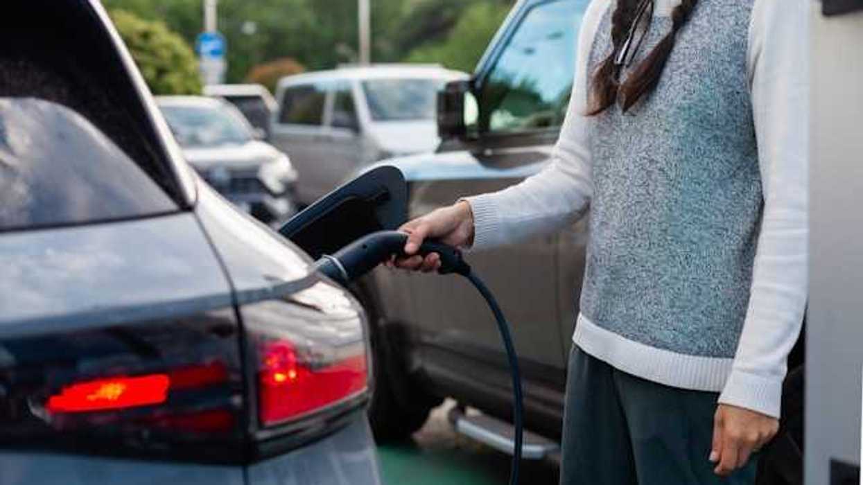 A woman charging an electric vehicle