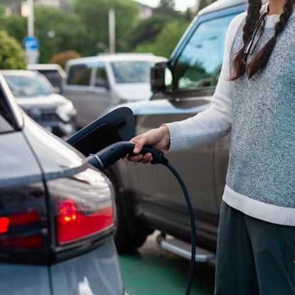 A woman charging an electric vehicle