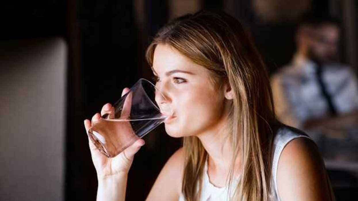 A woman drinking water out of a glass