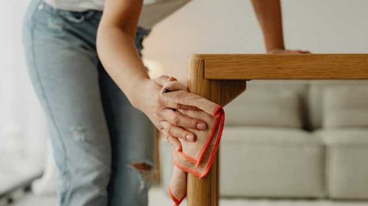 A woman dusting a small table