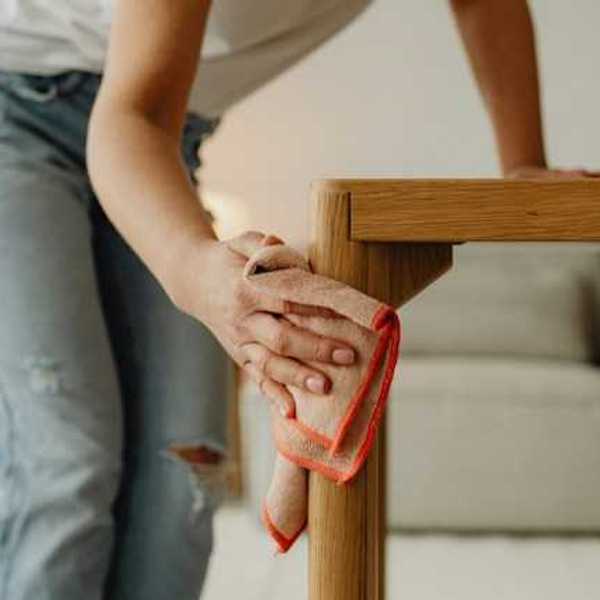A woman dusting a small table