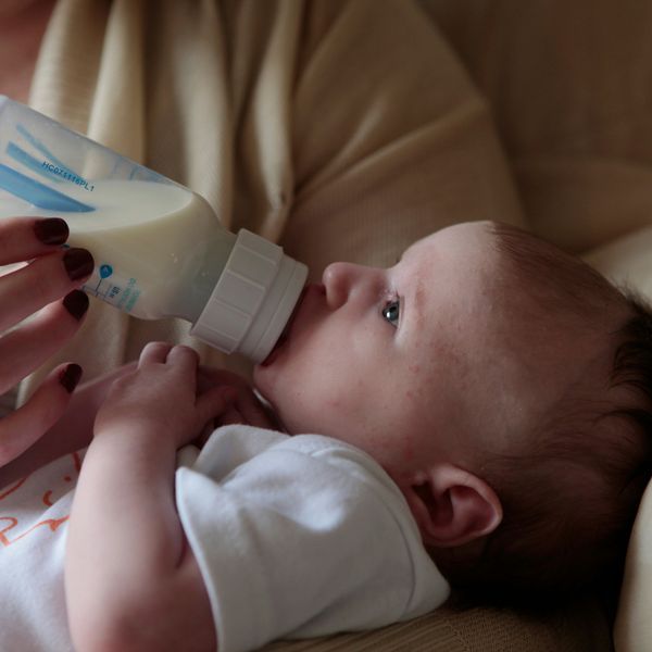 a woman feeding a baby with a bottle