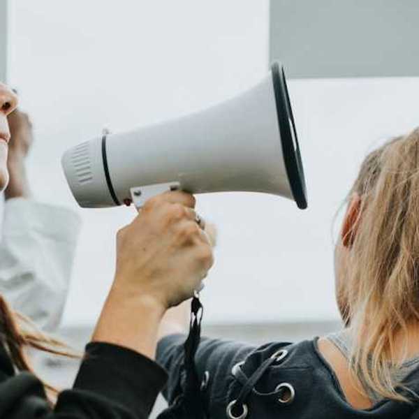 A woman holding a microphone at a protest