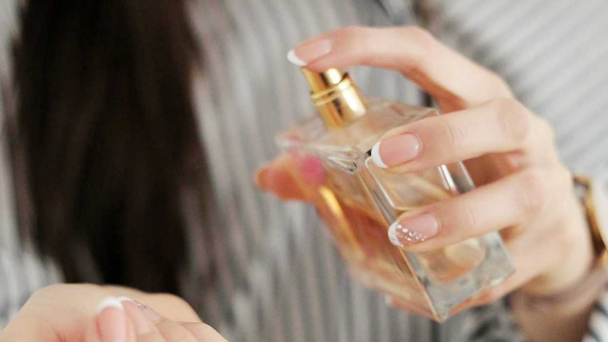 a woman holding a perfume bottle.