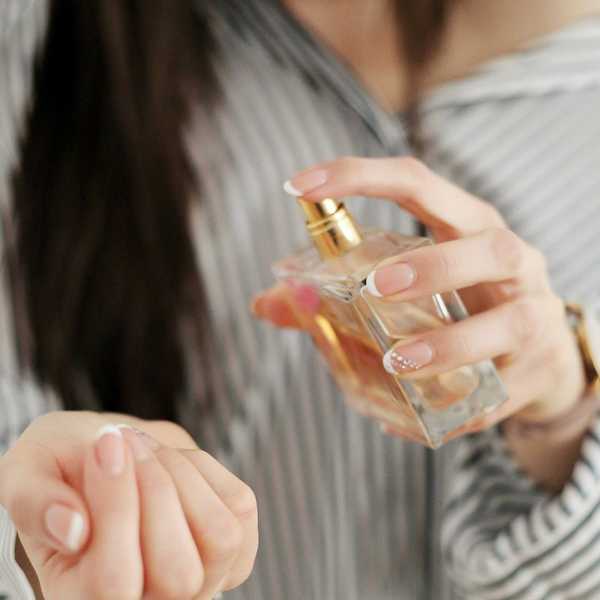 a woman holding a perfume bottle.