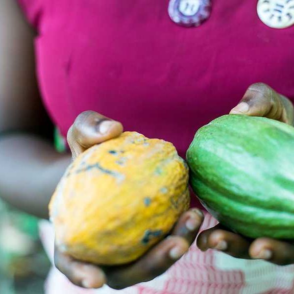 A woman holding yellow and green squash