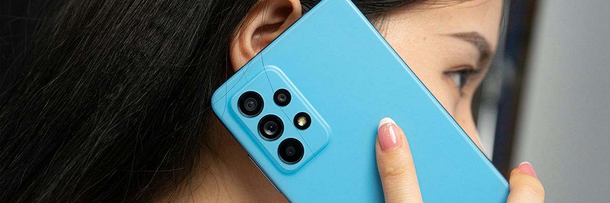 A woman holds a cell phone up to her ear.