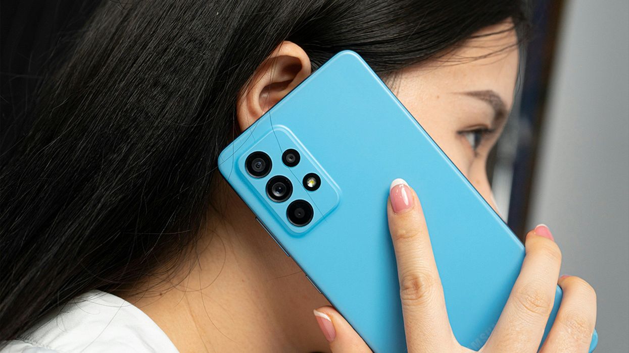 A woman holds a cell phone up to her ear.