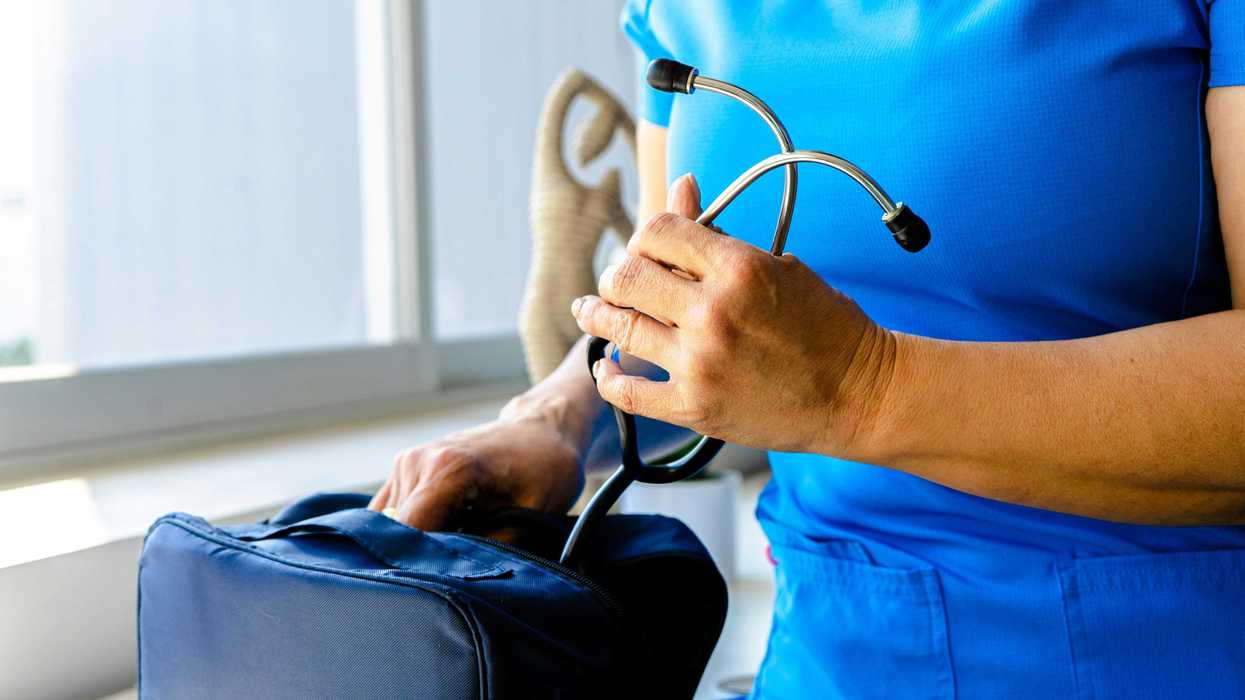 a woman in a blue scrub suit holding a stethoscope