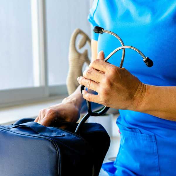 a woman in a blue scrub suit holding a stethoscope