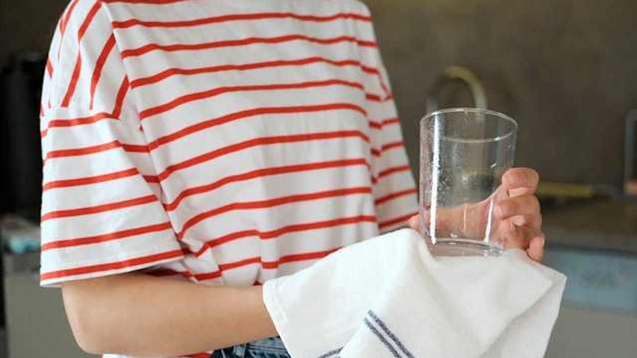 A woman in a striped shirt holding a glass