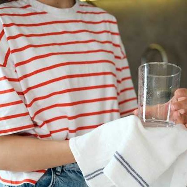 A woman in a striped shirt holding a glass