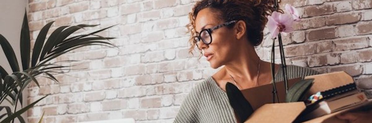 A woman packing up her office belongings in a cardboard box.