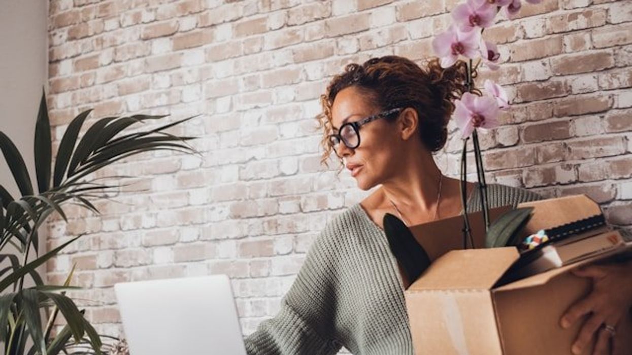 A woman packing up her office belongings in a cardboard box.