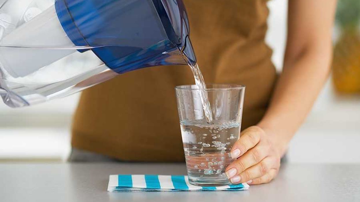 A woman pouring filtered water into a glass