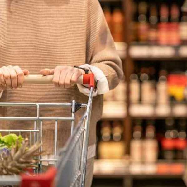 A woman pushing a shopping cart in a grocery store