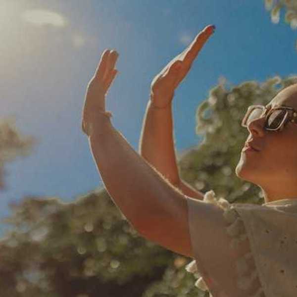 A woman shielding her face from the sun