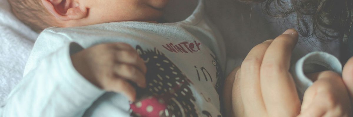 A woman snuggles a newborn