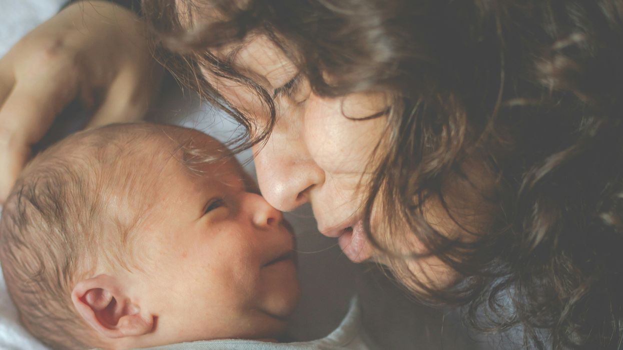 A woman snuggles a newborn
