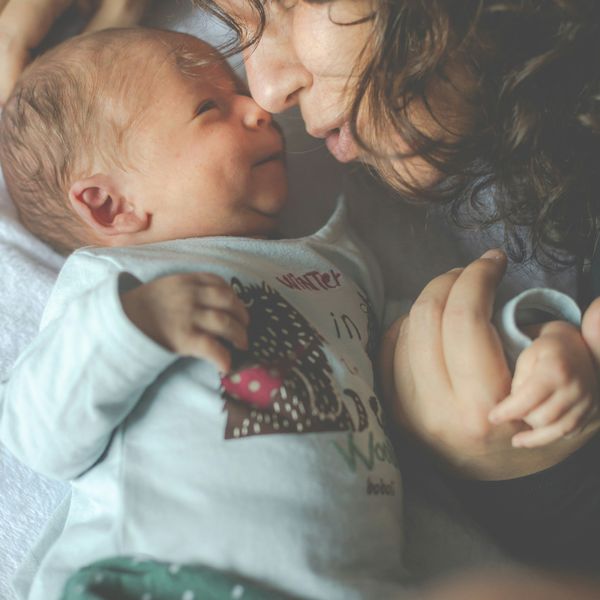 A woman snuggles a newborn