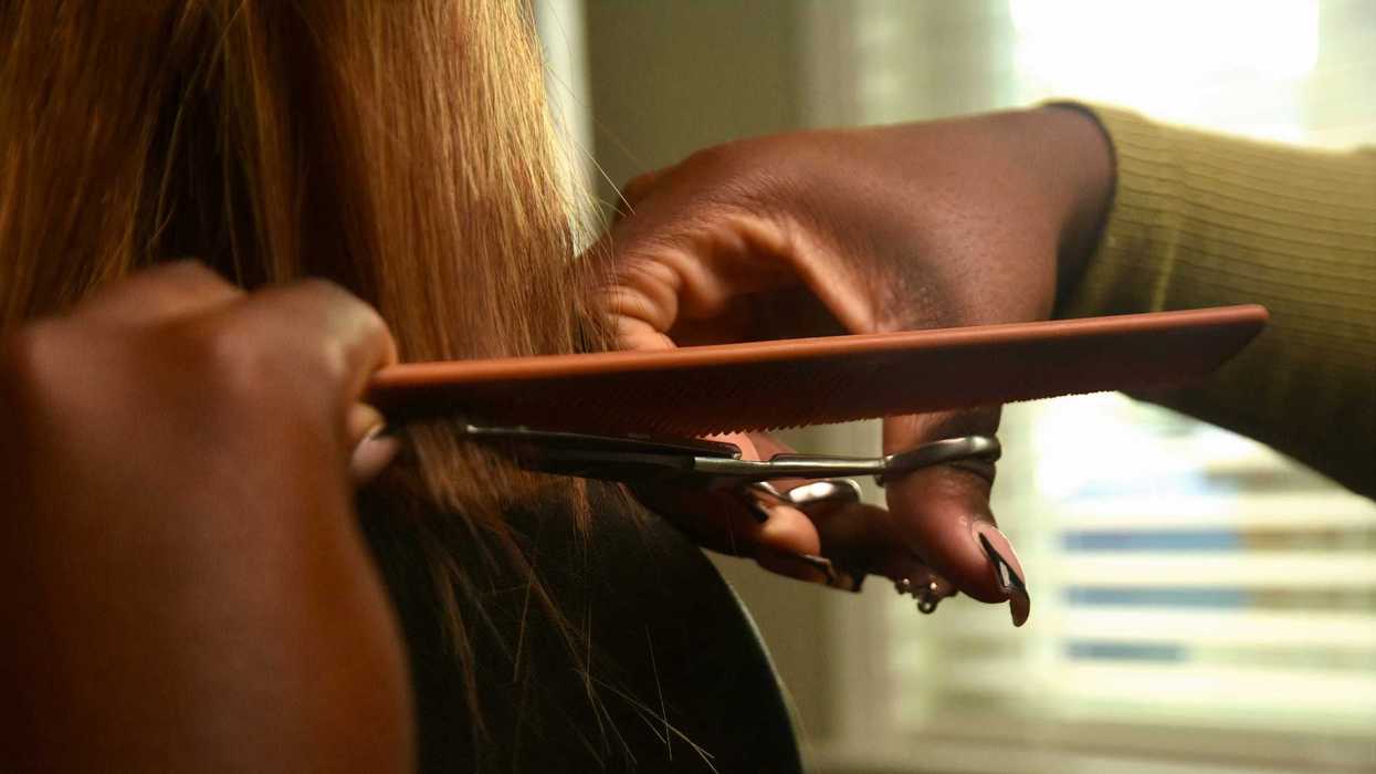 A woman styles another woman's hair