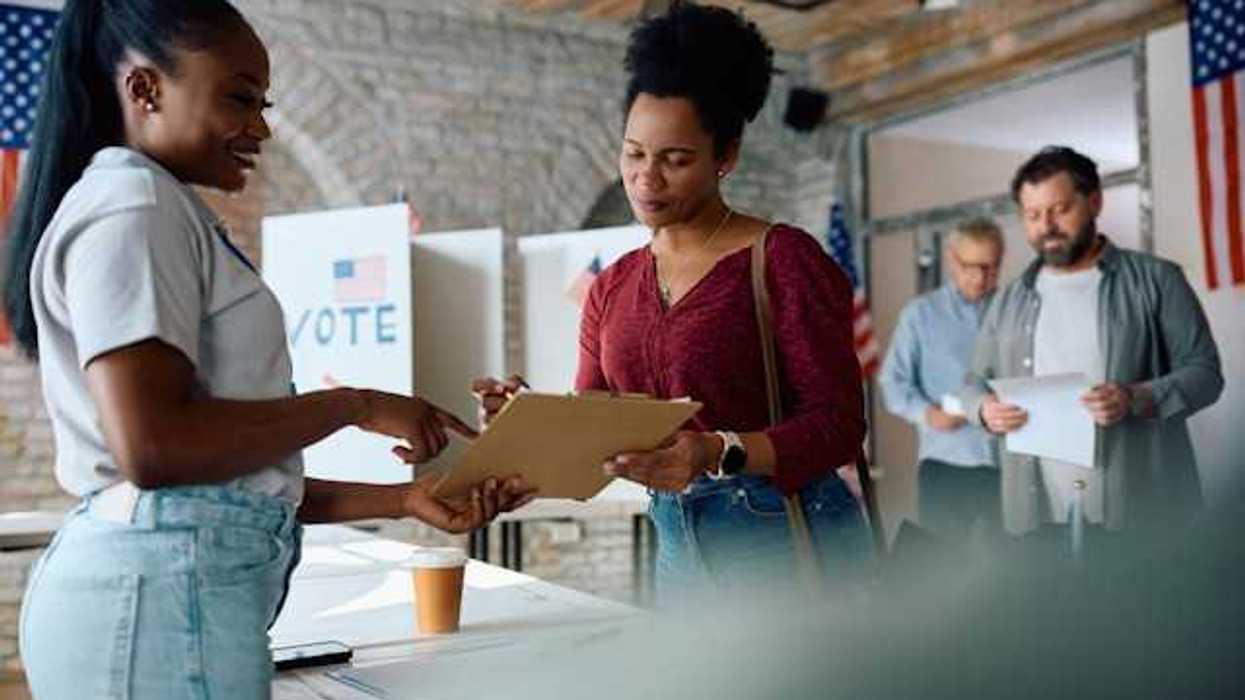 A woman talking to a voting representative at a polling station