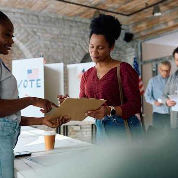 A woman talking to a voting representative at a polling station