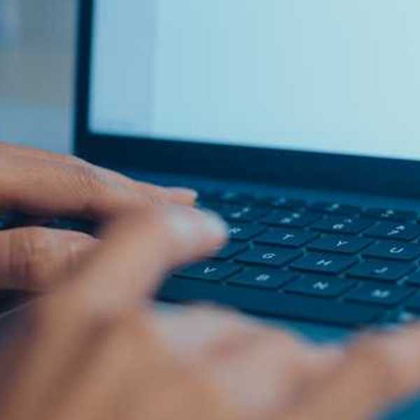 A woman typing on a laptop keyboard